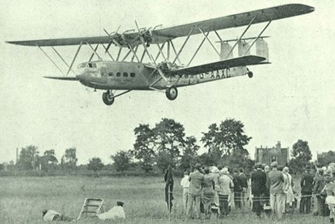 An image of a plane flying over a field