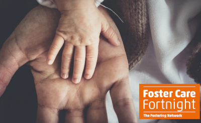 A child's hand resting on an adult hand with The Fostering Network logo
