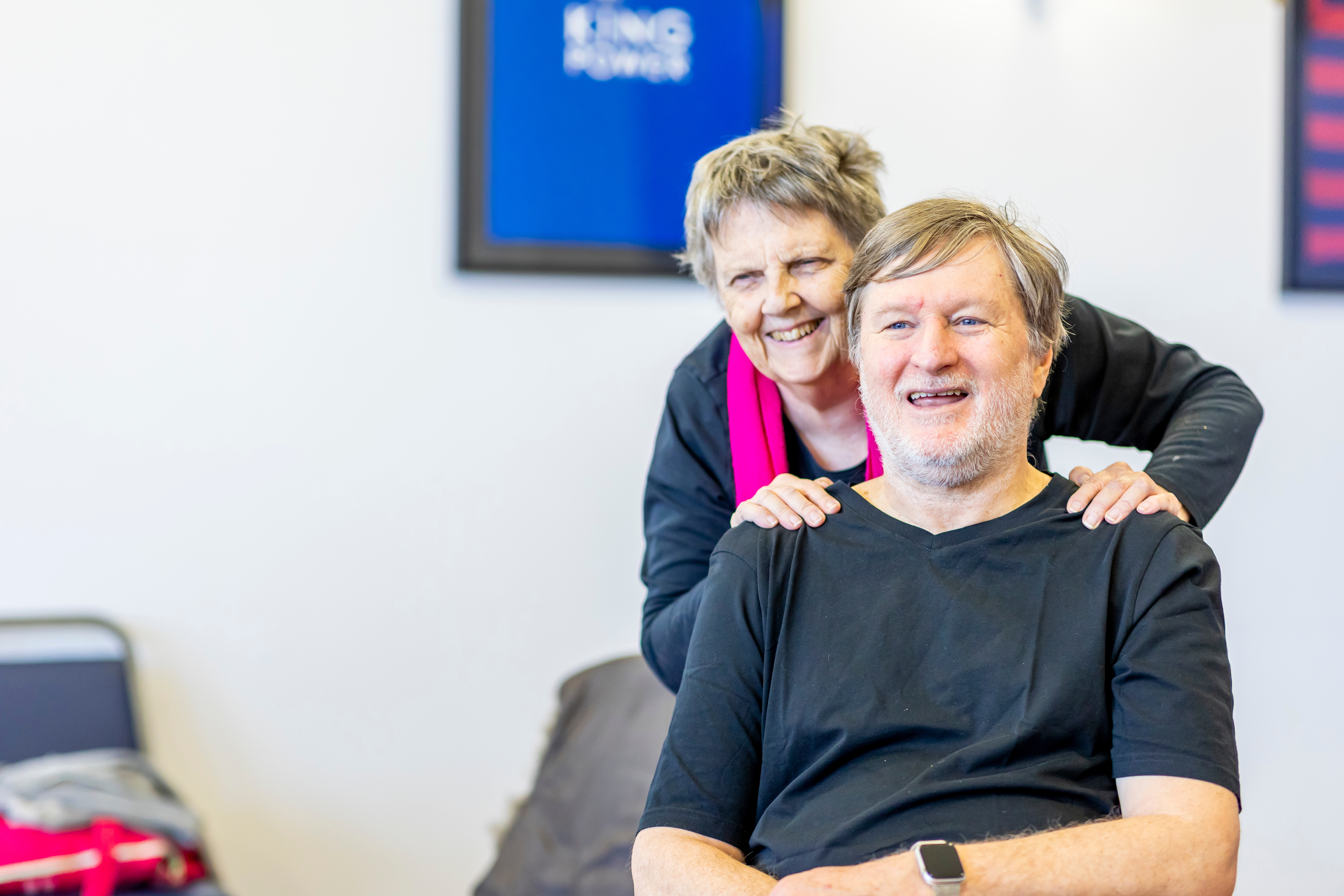 woman puts hands on smiling mans shoulders