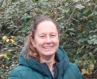 Image of Britt, SENDIASS Manager, with a hedge as a backdrop