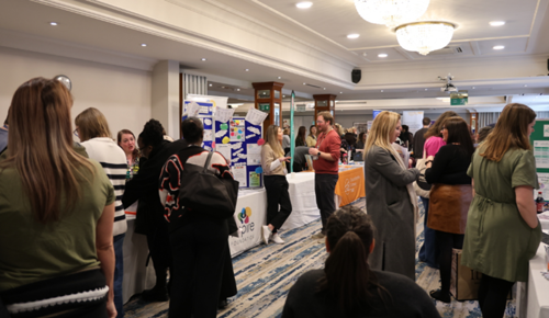 - A photograph of people who attended the SEND fair looking at information on tables and stands in a large room at the SEND Fair 2026.