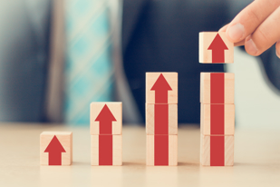 Some wooden blocks with red arrows pointing up drawn on them.