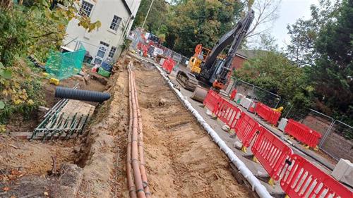 Photo of work area from above showing wall removed and cables below ground level