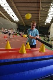 Young man trying out bat and ball game inside the Oxstalls sports centre.