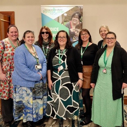 1.	A photograph of seven adult females, who are the Gloucestershire Parent Carer Forum team, standing in front of a banner promoting their work at the SEND Fair 2026.