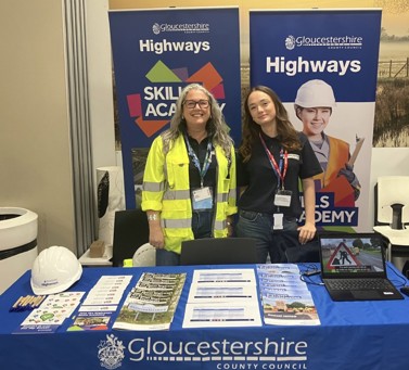 Photo of stall at careers event with blue pop up banners and two officers