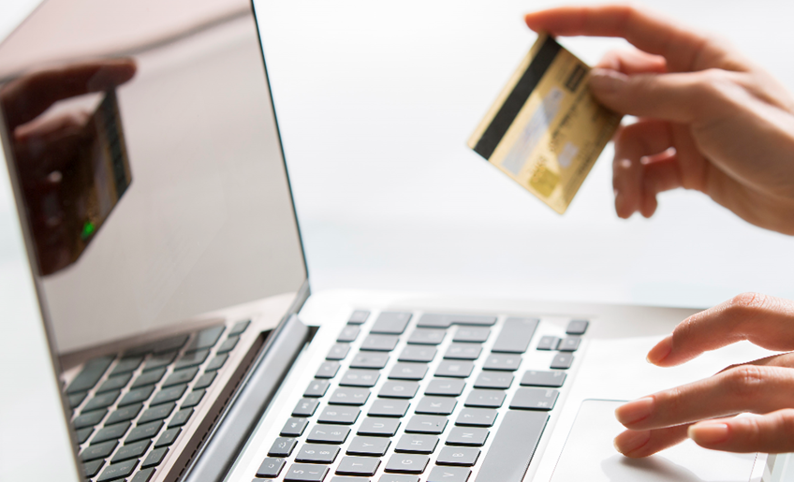 Person paying with a credit card at their laptop