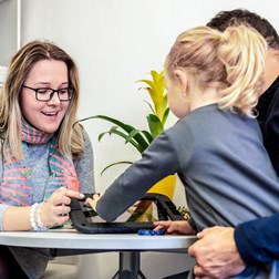 An image of a social worker talking to a child and her father