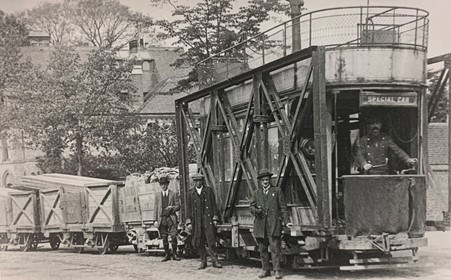 An image of men stood in front of a tram