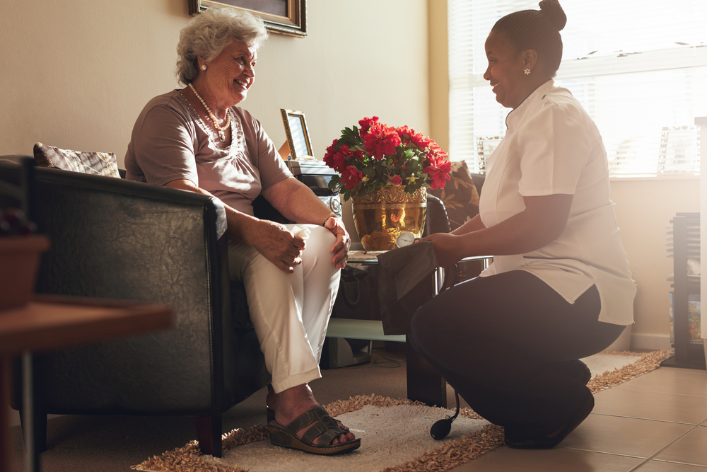 senior woman is supported at home by care worker