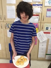 A boy holding a plate of scones