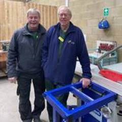 Two men standing next to a blue machine

AI-generated content may be incorrect.