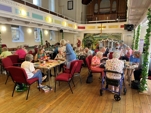Holiday at Home event with people sat at tables taking part in crafting activities