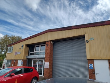 A picture of the GIS building which is a mustard coloured big warehouse building with a cargo bay door.