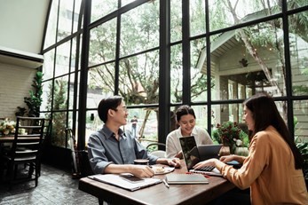 A image of three people working at a table together