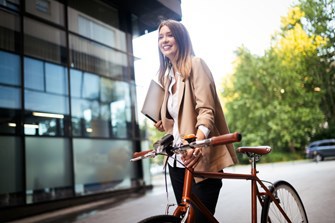 A women walking while pushing along her bicycle
