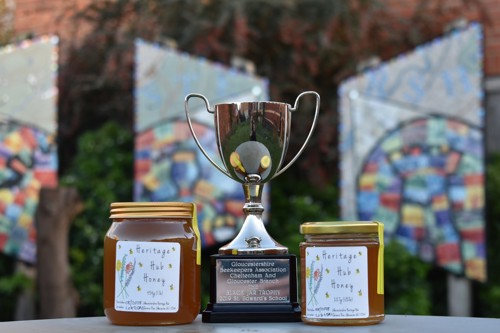Two jars of Heritage Hub Honey next to the taste test trophy they won.