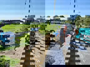 View from the bridge of the crane grabbing something off the bridge, with a digger on the road.