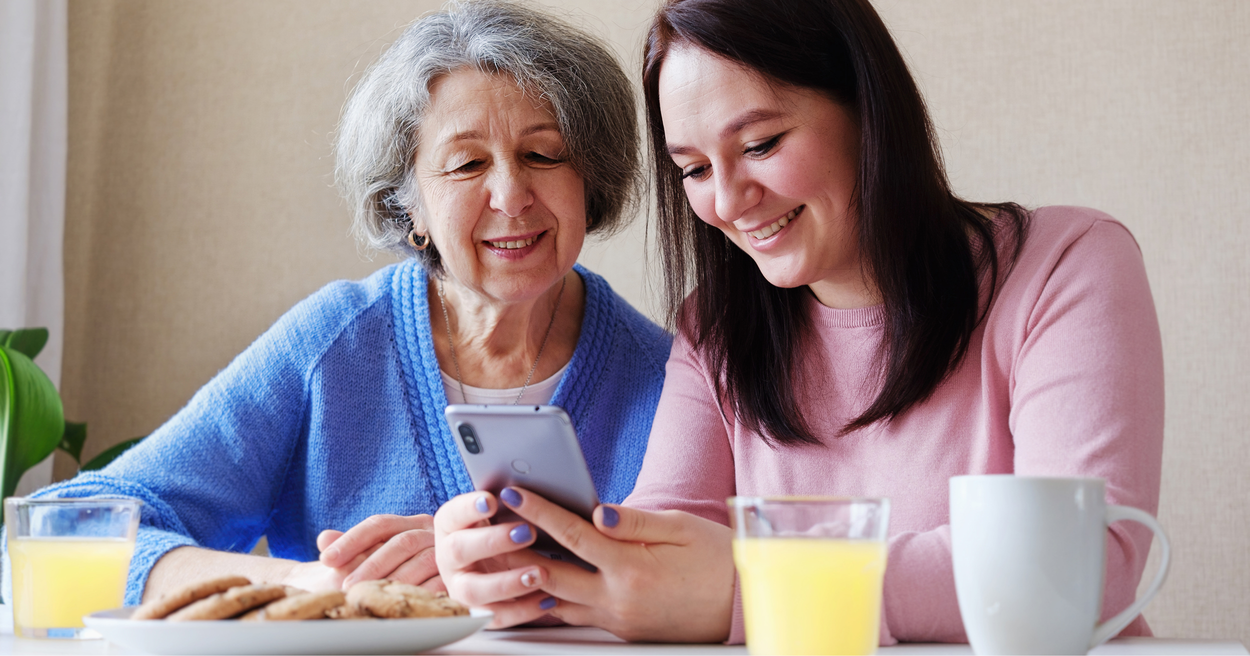 Mum and daughter using a mobile phone at the dinner table
